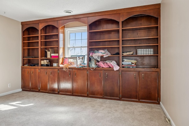 unfurnished office with baseboards, visible vents, and light colored carpet