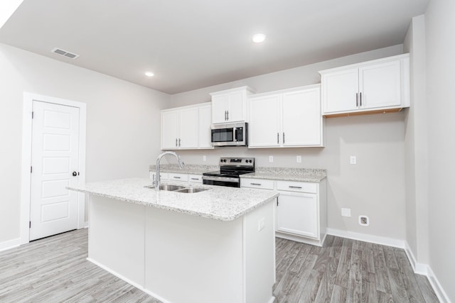 kitchen with a center island with sink, stainless steel appliances, visible vents, white cabinets, and a sink