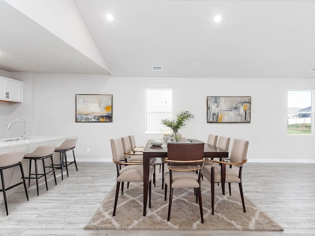 dining area featuring baseboards, recessed lighting, lofted ceiling, and light wood-style floors