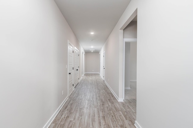 hallway featuring baseboards and light wood-style floors