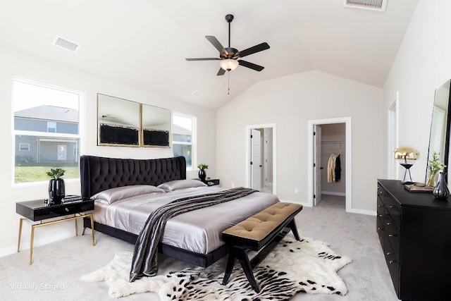 bedroom with lofted ceiling, visible vents, a spacious closet, light carpet, and baseboards