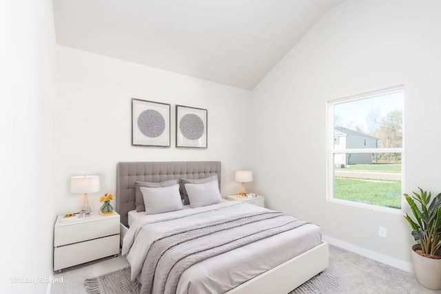 carpeted bedroom with vaulted ceiling and baseboards