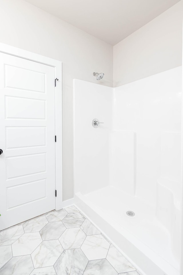 full bath with marble finish floor and a shower