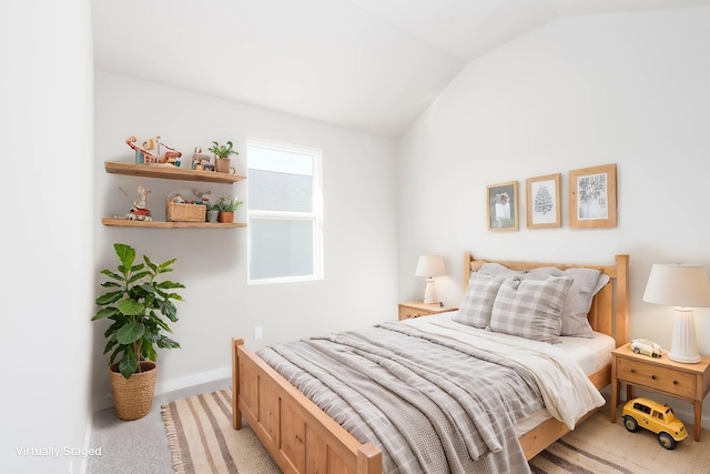 bedroom with lofted ceiling, baseboards, and light colored carpet