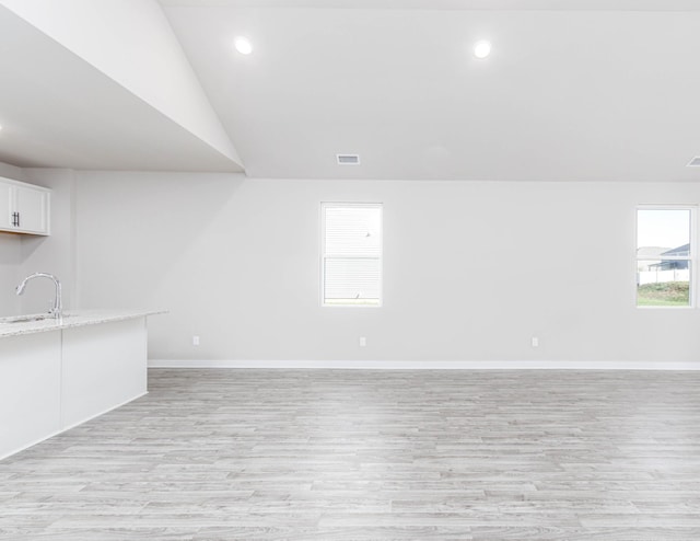 spare room with recessed lighting, visible vents, light wood-style floors, a sink, and baseboards