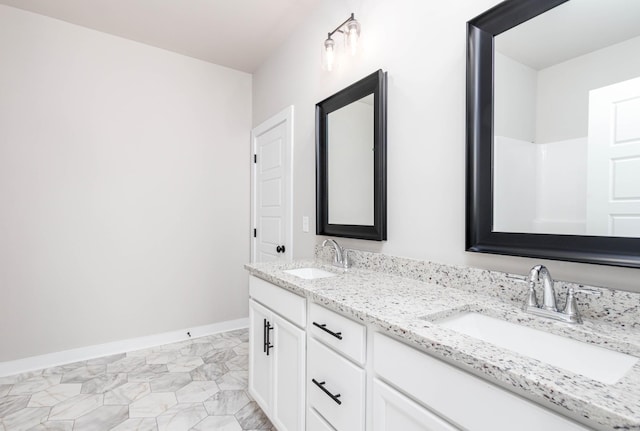 bathroom with a sink, baseboards, and double vanity