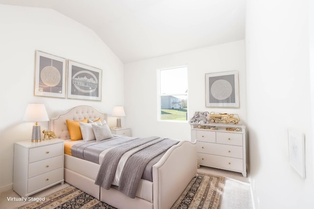 bedroom with vaulted ceiling and light carpet