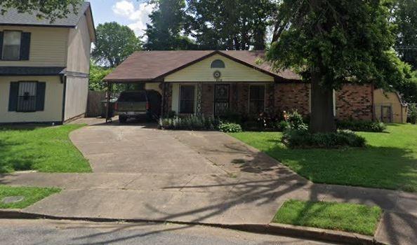 view of front of house with a carport, driveway, and a front lawn