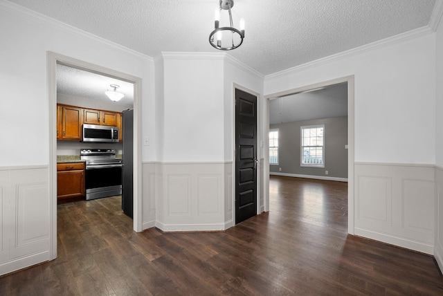 interior space with crown molding, a textured ceiling, dark wood-style flooring, and wainscoting