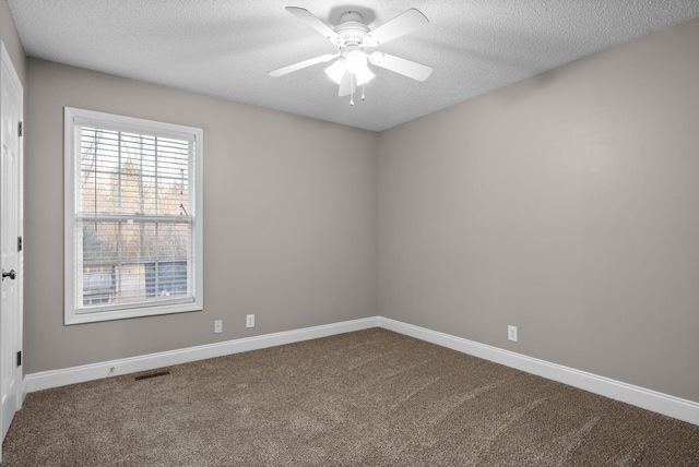 empty room with baseboards, visible vents, ceiling fan, a textured ceiling, and dark carpet