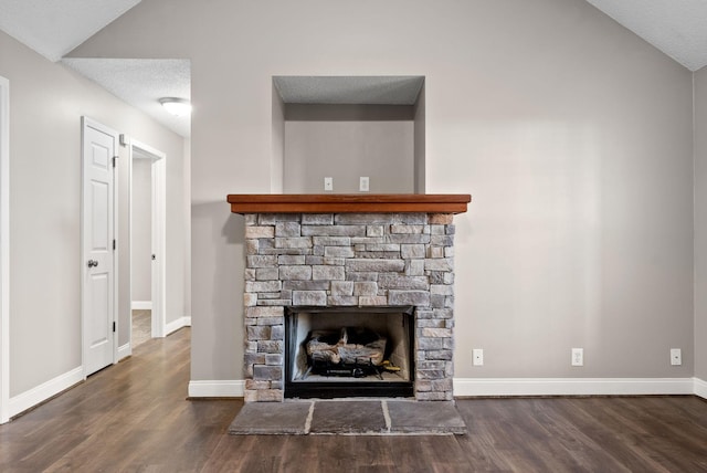 room details with a textured ceiling, a stone fireplace, wood finished floors, and baseboards