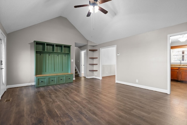 unfurnished living room featuring dark wood-style floors, visible vents, vaulted ceiling, a sink, and ceiling fan