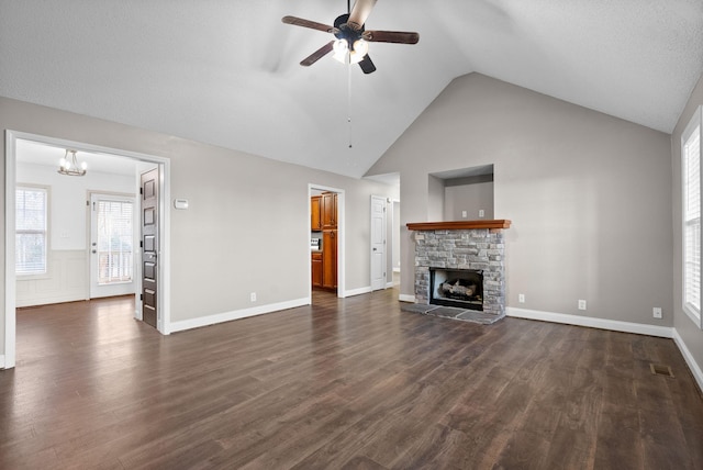 unfurnished living room with dark wood finished floors, a fireplace, visible vents, high vaulted ceiling, and ceiling fan with notable chandelier