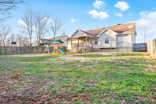 exterior space with crawl space, a fenced backyard, a yard, and a playground