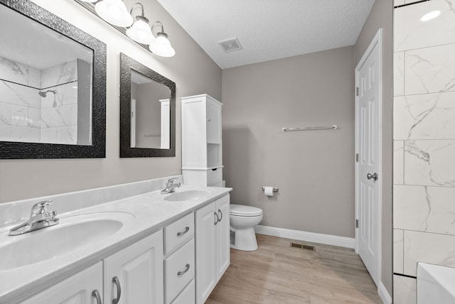 bathroom with visible vents, a sink, and a textured ceiling