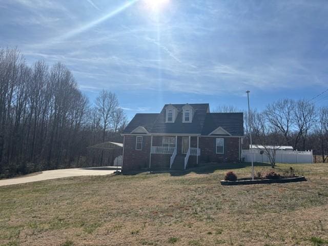 view of front of property with a porch, fence, and a front lawn