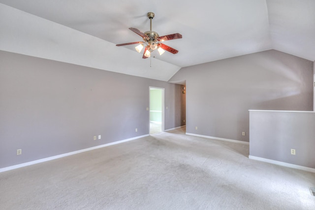 spare room with baseboards, lofted ceiling, carpet floors, and ceiling fan