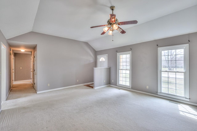 unfurnished living room featuring visible vents, baseboards, lofted ceiling, ceiling fan, and light carpet