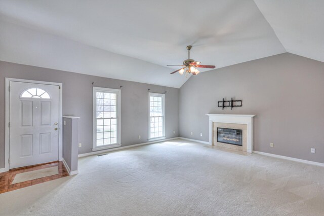 unfurnished living room featuring lofted ceiling, light colored carpet, baseboards, and a premium fireplace