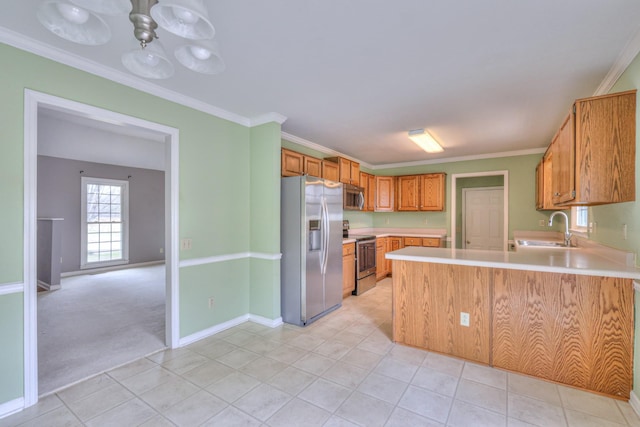 kitchen with a sink, stainless steel appliances, ornamental molding, and light countertops