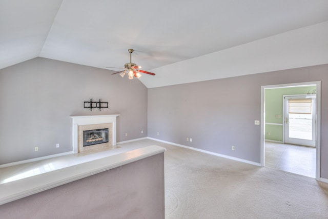 unfurnished living room featuring a ceiling fan, lofted ceiling, light colored carpet, and a fireplace