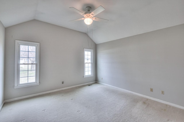 empty room with a ceiling fan, baseboards, visible vents, vaulted ceiling, and carpet flooring