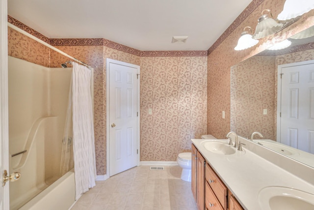 full bath with a sink, baseboards, toilet, and wallpapered walls