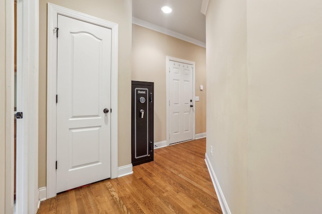 hallway featuring recessed lighting, baseboards, light wood-style floors, and ornamental molding