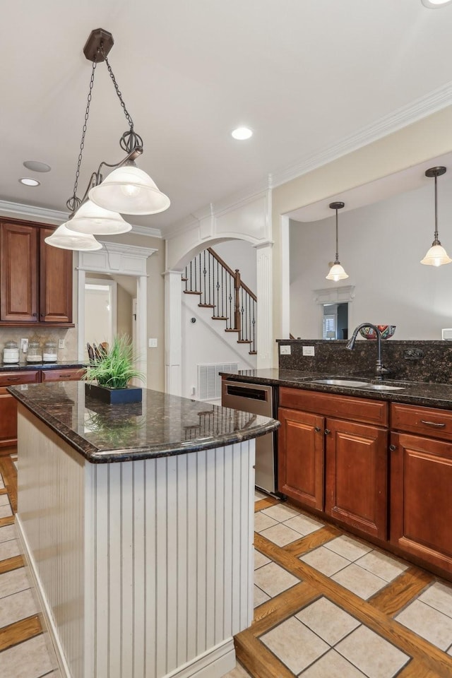 kitchen with a center island, crown molding, stainless steel dishwasher, arched walkways, and a sink