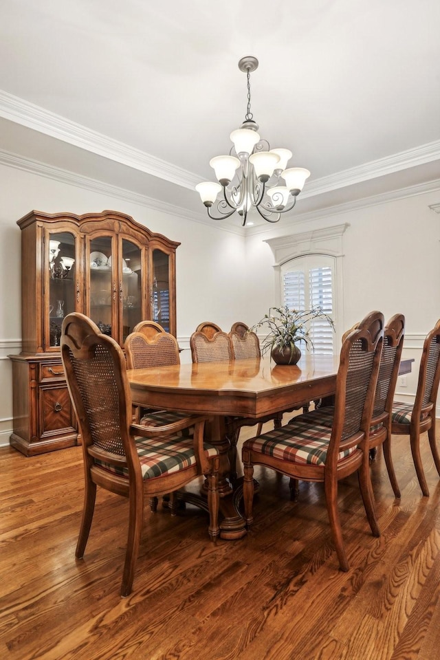 dining room featuring a notable chandelier, light wood-style flooring, and ornamental molding