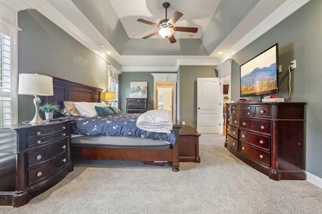 carpeted bedroom with ceiling fan, a raised ceiling, and ornamental molding