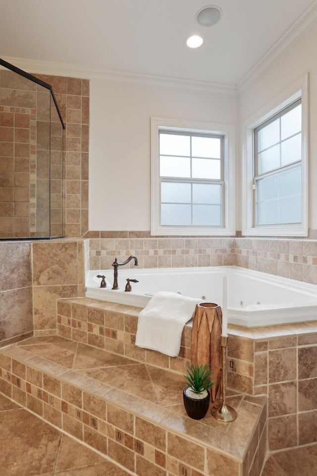 bathroom with crown molding, a tub with jets, and tiled shower