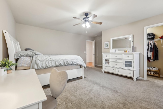 bedroom featuring baseboards, ceiling fan, a spacious closet, a closet, and light carpet