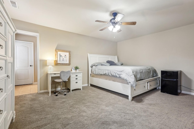 carpeted bedroom with baseboards, visible vents, freestanding refrigerator, and ceiling fan