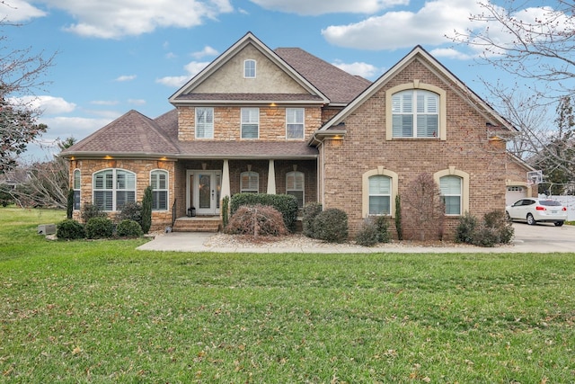 view of front of home featuring a shingled roof, concrete driveway, stone siding, a front yard, and brick siding