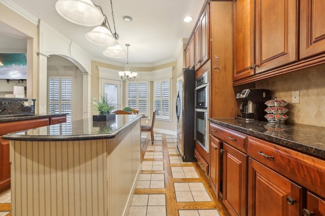 kitchen with backsplash, a kitchen island, ornamental molding, stainless steel appliances, and a sink