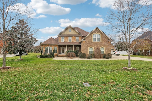 traditional-style home featuring a front yard, brick siding, and driveway