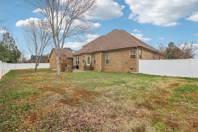 back of house featuring a fenced backyard, entry steps, crawl space, a lawn, and brick siding