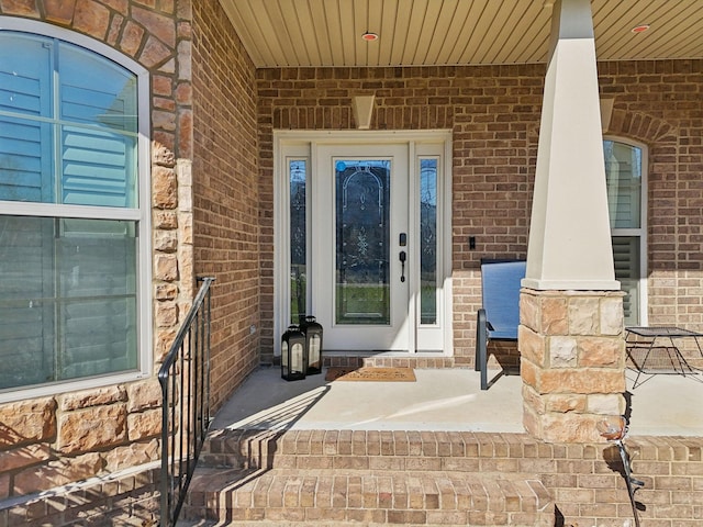 property entrance with brick siding and a porch