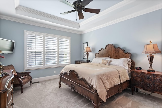 carpeted bedroom with ornamental molding, a raised ceiling, a ceiling fan, and baseboards