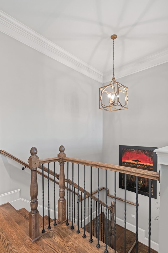 staircase featuring ornamental molding, a fireplace, baseboards, and wood finished floors