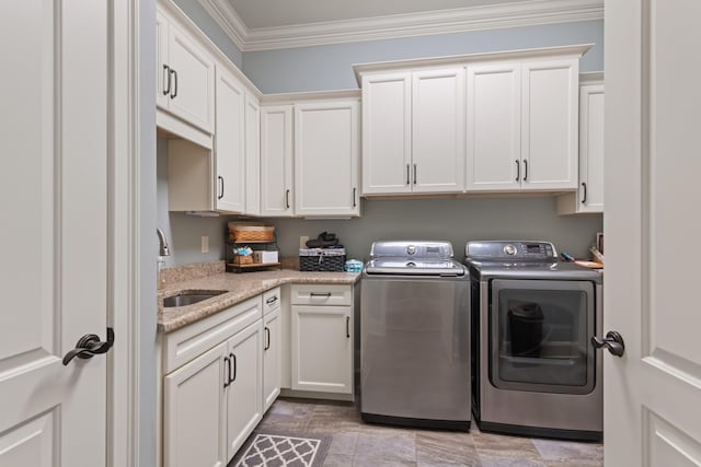 laundry room featuring a sink, cabinet space, crown molding, and independent washer and dryer