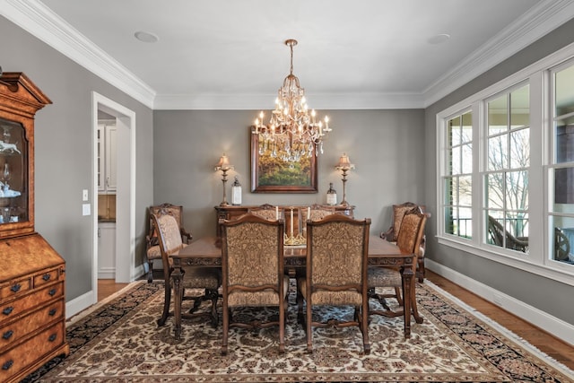 dining room with ornamental molding, wood finished floors, and baseboards