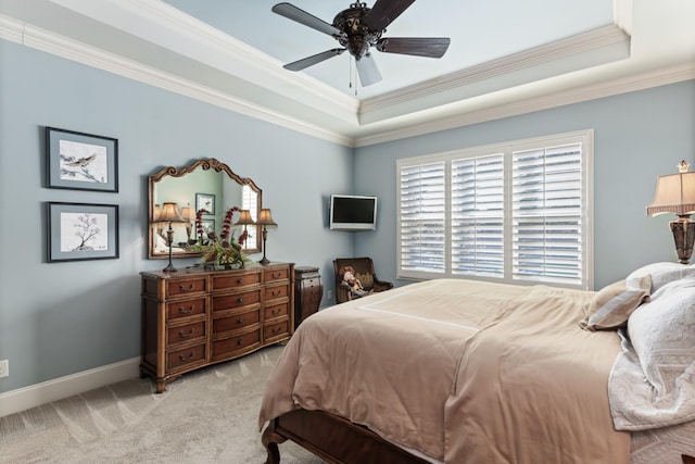 carpeted bedroom with baseboards, a tray ceiling, ceiling fan, and crown molding