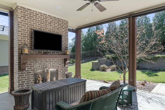 view of patio featuring an outdoor brick fireplace, fence, and a ceiling fan