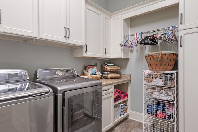 washroom with baseboards, cabinet space, and washing machine and clothes dryer