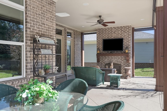 view of patio / terrace with an outdoor brick fireplace, outdoor dining space, and a ceiling fan