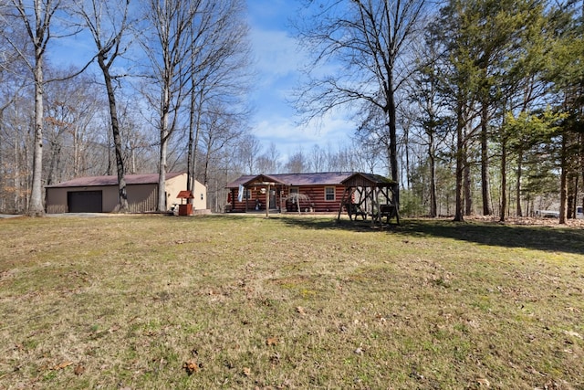 view of yard featuring a garage and an outbuilding