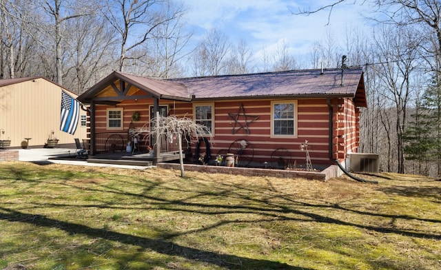 rear view of house featuring a yard, metal roof, and central AC unit