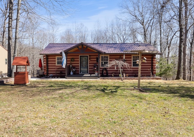 log home featuring a front yard, metal roof, and log exterior